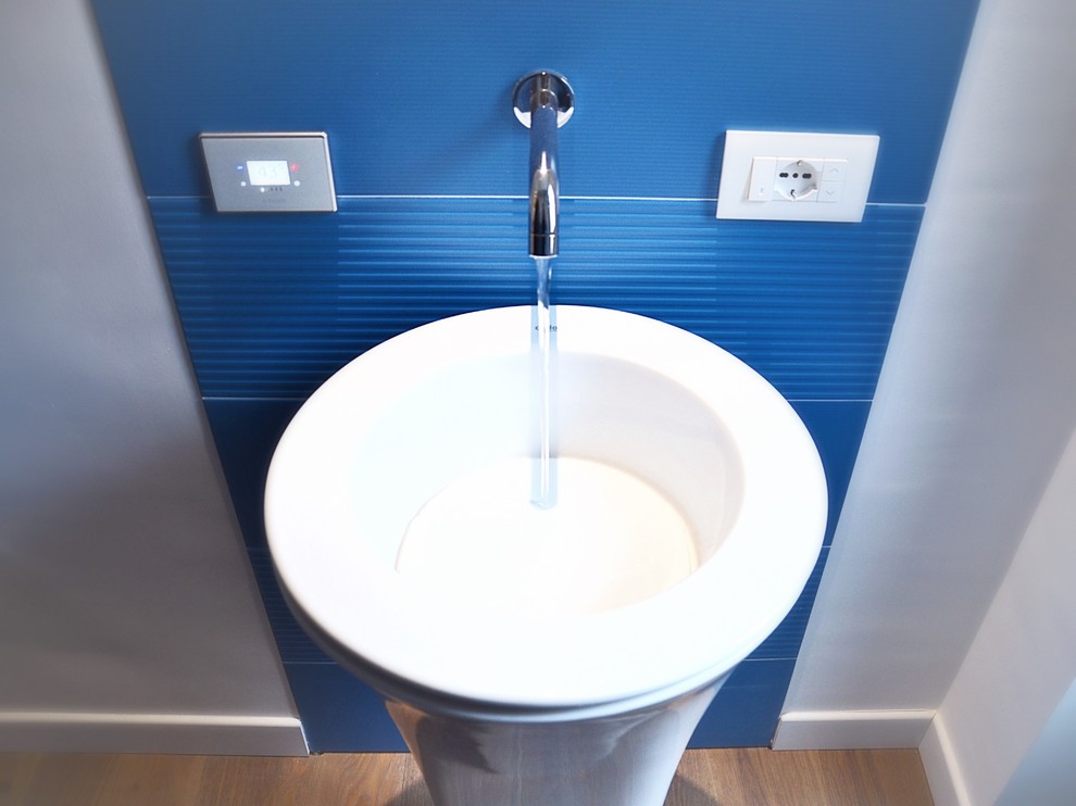Foto di una stanza da bagno contemporanea con piastrelle blu, piastrelle in gres porcellanato e lavabo a colonna