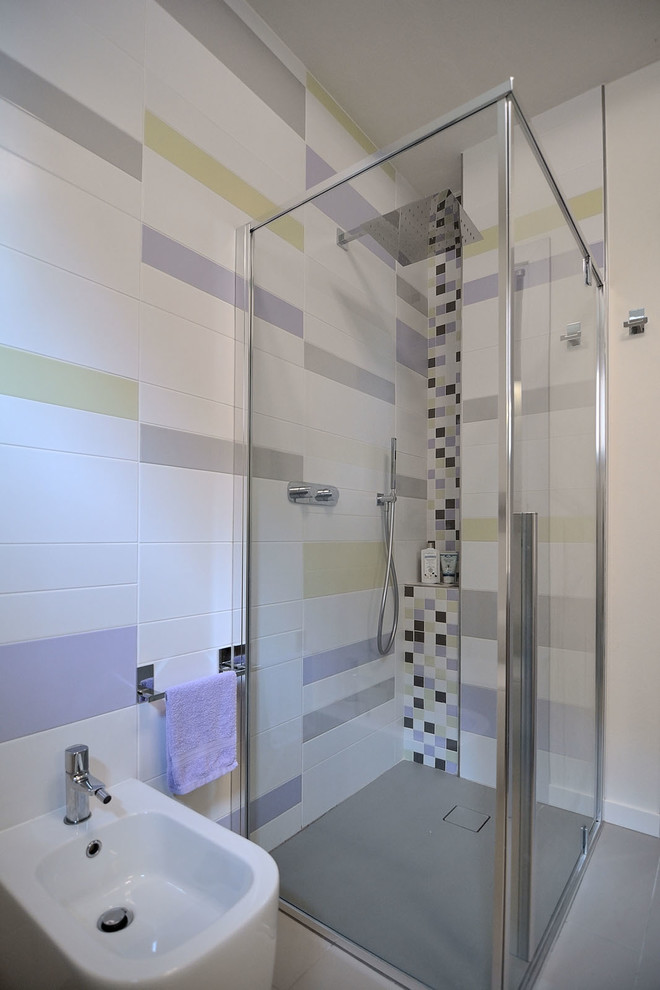 Exempel på ett mellanstort modernt lila lila badrum, med släta luckor, lila skåp, en toalettstol med separat cisternkåpa, flerfärgad kakel, keramikplattor, flerfärgade väggar, klinkergolv i keramik, ett avlångt handfat, bänkskiva i glas, grått golv, en kantlös dusch och dusch med gångjärnsdörr