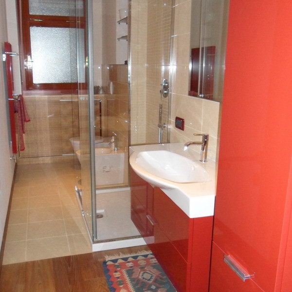 Свежая идея для дизайна: ванная комната в стиле модернизм с плоскими фасадами, красными фасадами, бежевой плиткой и керамогранитной плиткой - отличное фото интерьера