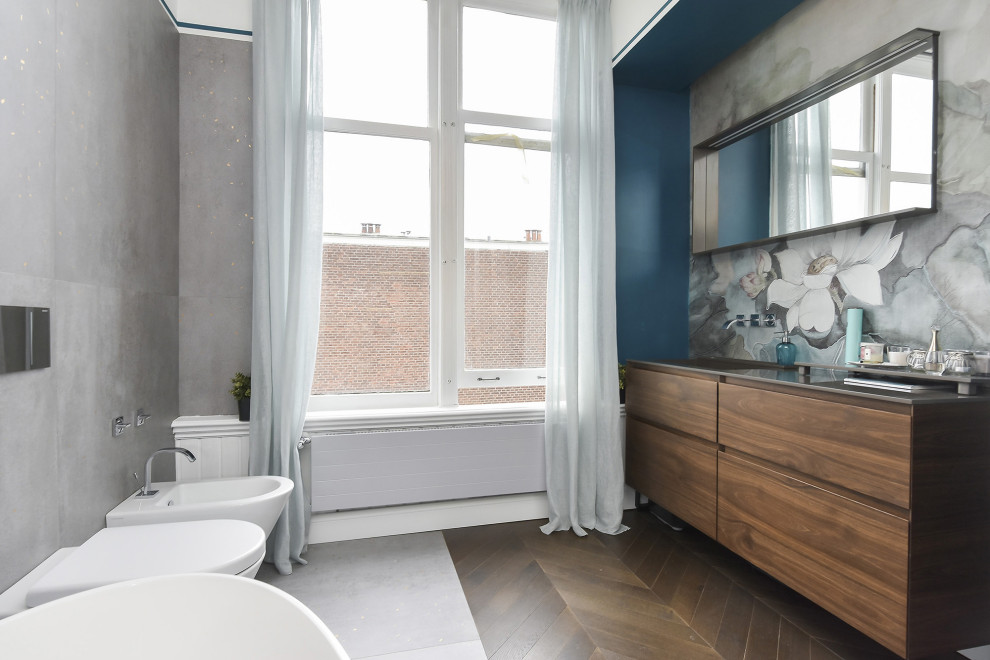 Exempel på ett modernt svart svart en-suite badrum, med släta luckor, skåp i mellenmörkt trä, ett fristående badkar, en vägghängd toalettstol, cementkakel, flerfärgade väggar, ett undermonterad handfat och brunt golv