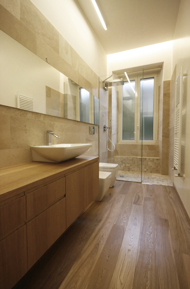 Esempio di una stanza da bagno minimal con lavabo a bacinella, ante lisce, ante in legno scuro, top in legno, doccia a filo pavimento, bidè, piastrelle beige e pavimento in legno massello medio
