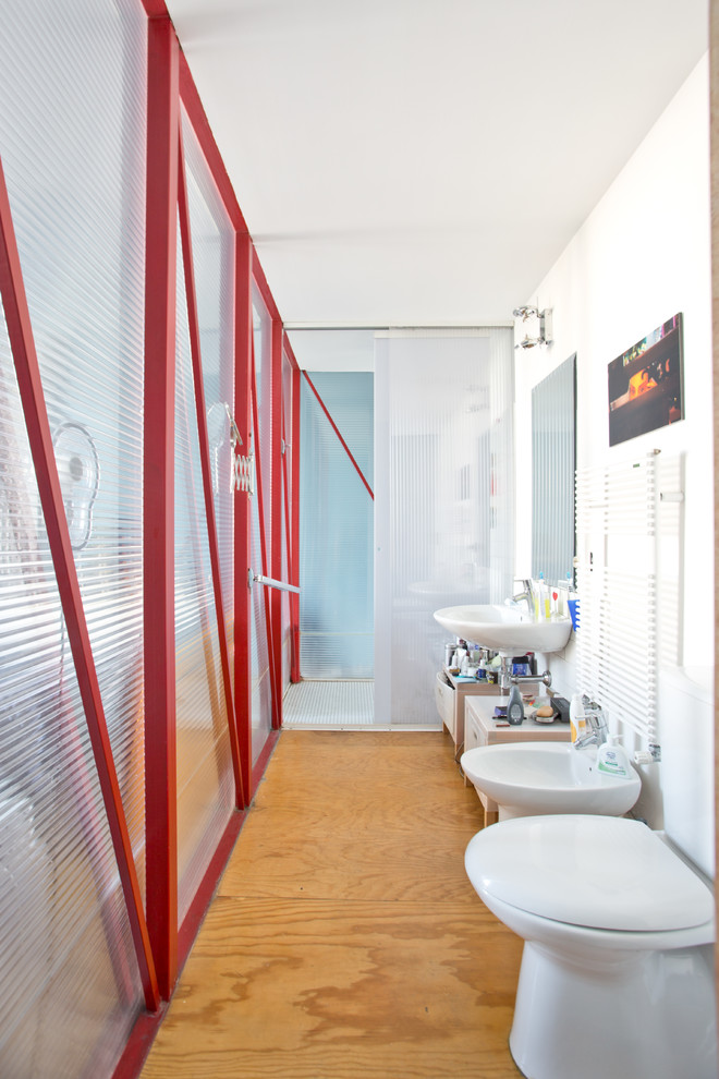 ローマにある中くらいなエクレクティックスタイルのおしゃれな浴室 (ビデ、白い壁、無垢フローリング、壁付け型シンク) の写真