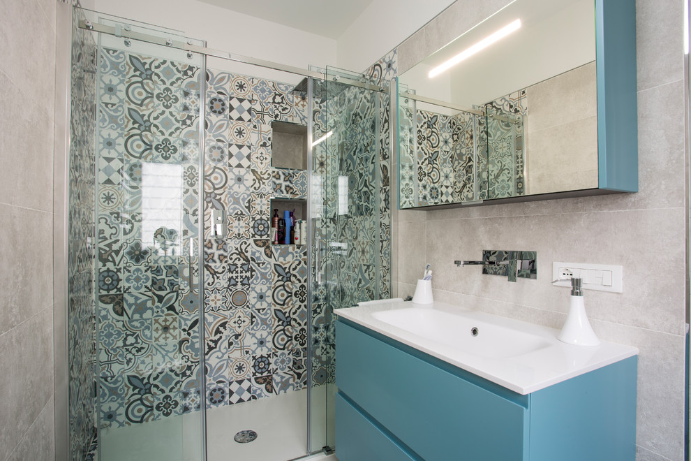 Идея дизайна: маленькая главная ванная комната в морском стиле с плоскими фасадами, синими фасадами, душем в нише, инсталляцией, разноцветной плиткой, керамической плиткой, бежевыми стенами, монолитной раковиной и душем с раздвижными дверями для на участке и в саду