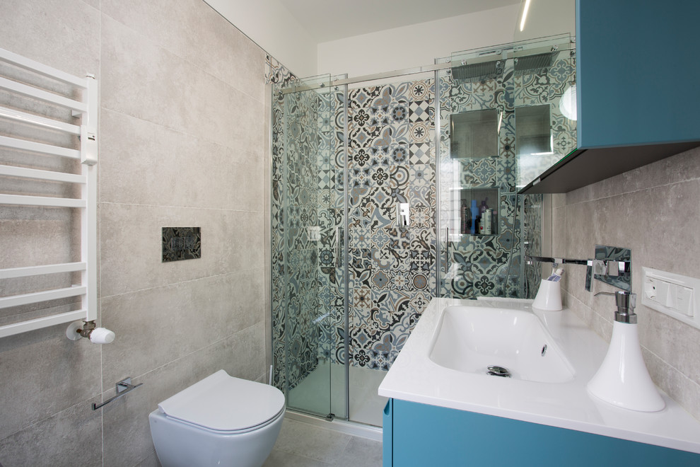 Пример оригинального дизайна: маленькая главная ванная комната в морском стиле с плоскими фасадами, синими фасадами, душем в нише, инсталляцией, разноцветной плиткой, керамической плиткой, бежевыми стенами, монолитной раковиной и душем с раздвижными дверями для на участке и в саду