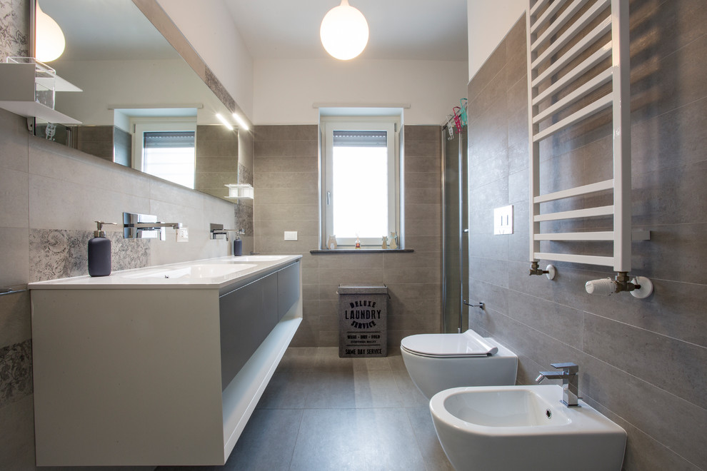 Small modern ensuite bathroom in Rome with flat-panel cabinets, beige cabinets, an alcove shower, a bidet, ceramic tiles, beige walls, an integrated sink and a sliding door.