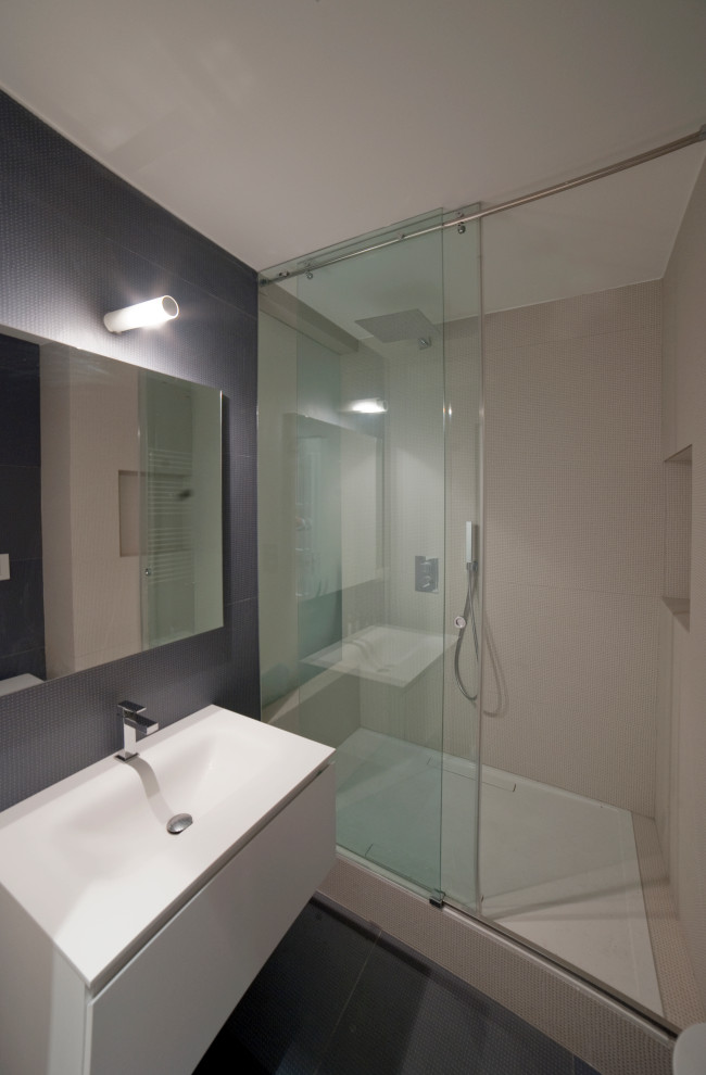 Immagine di una piccola stanza da bagno con doccia minimal con ante a filo, ante bianche, piastrelle in gres porcellanato, top in superficie solida, top bianco, un lavabo e mobile bagno sospeso