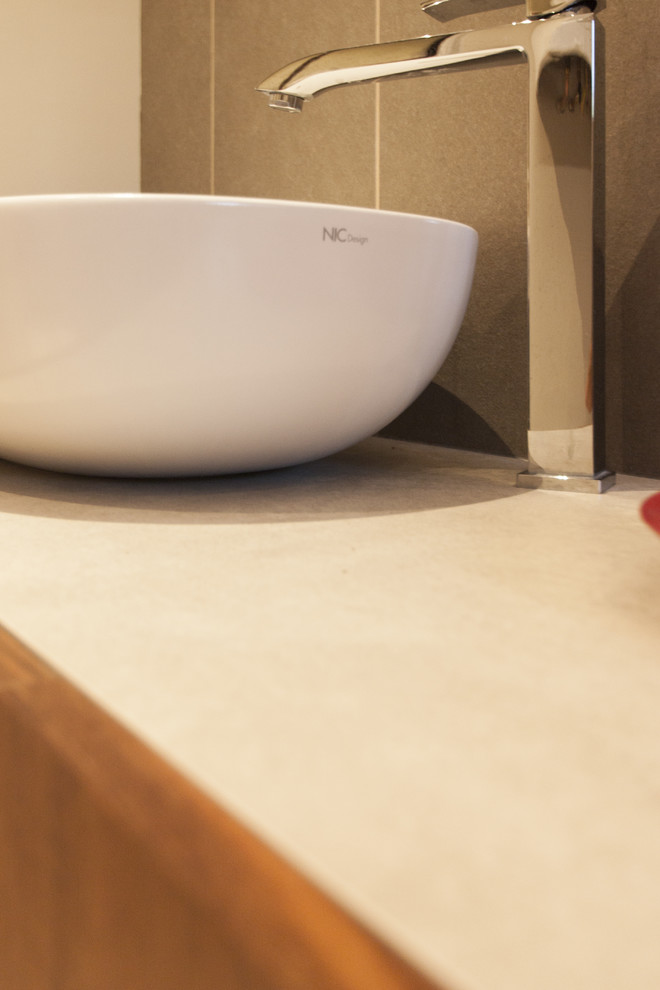 Immagine di una grande stanza da bagno con doccia design con ante lisce, ante in legno scuro, piastrelle grigie, piastrelle in ceramica, top piastrellato e top beige