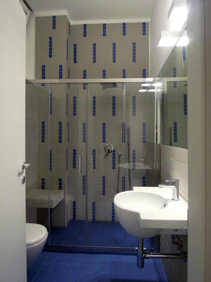 Idéer för små industriella badrum med dusch, med en dusch i en alkov, en vägghängd toalettstol, grå kakel, mosaik, grå väggar, klinkergolv i porslin, ett väggmonterat handfat, blått golv och dusch med skjutdörr