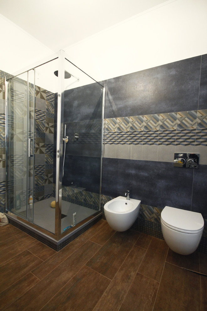 Esempio di una grande stanza da bagno con doccia moderna con WC sospeso, piastrelle blu, piastrelle in gres porcellanato, pareti bianche, lavabo da incasso, top in laminato, doccia ad angolo, parquet scuro, pavimento marrone e porta doccia scorrevole