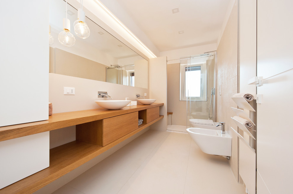 Idée de décoration pour une salle de bain design en bois brun avec un placard à porte plane, un bidet, un mur blanc, une vasque, un plan de toilette en bois, un sol beige, une cabine de douche à porte coulissante et un plan de toilette marron.