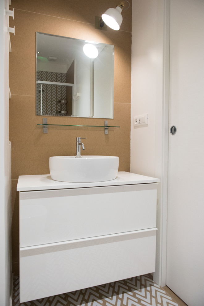 ローマにあるお手頃価格の小さなコンテンポラリースタイルのおしゃれなバスルーム (浴槽なし) (白いキャビネット、分離型トイレ、ベージュのタイル、磁器タイル、白い壁、磁器タイルの床、ベッセル式洗面器、ラミネートカウンター、フラットパネル扉のキャビネット、コーナー設置型シャワー、マルチカラーの床、引戸のシャワー、白い洗面カウンター) の写真