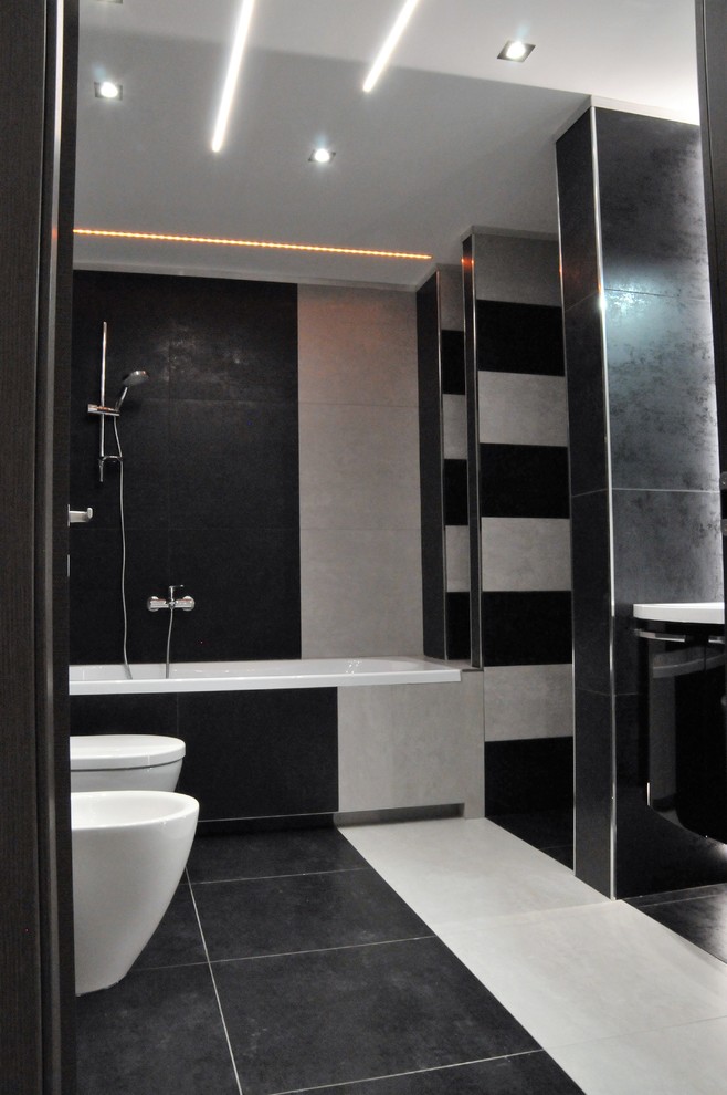 Idées déco pour une salle de bain contemporaine de taille moyenne avec des portes de placard noires, une baignoire posée, WC séparés, un mur noir, un sol en carrelage de porcelaine, un lavabo intégré, un sol noir et une cabine de douche à porte battante.