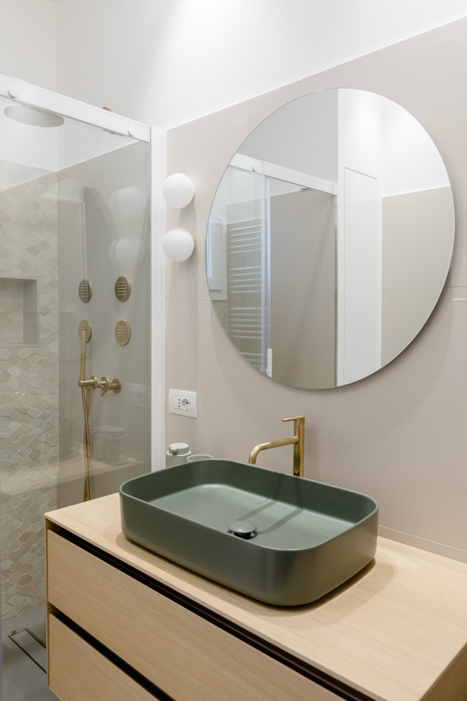 Idéer för att renovera ett mellanstort funkis beige beige badrum med dusch, med släta luckor, skåp i ljust trä, en dusch i en alkov, beige kakel, porslinskakel, vita väggar, ett fristående handfat och träbänkskiva