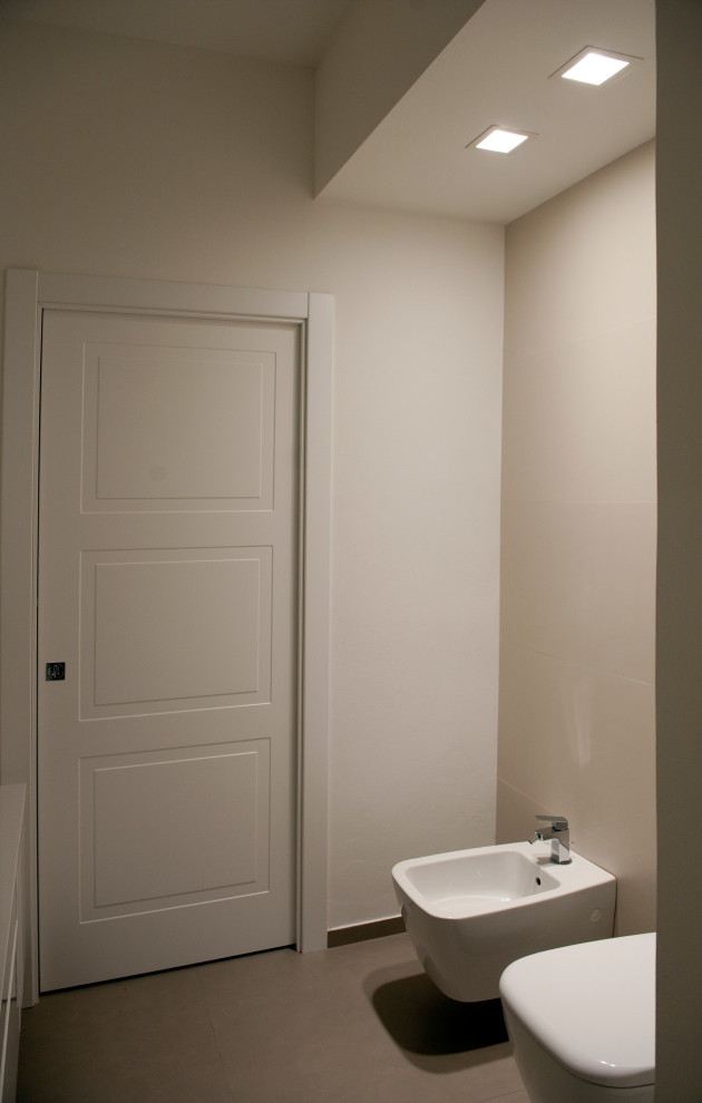 Inspiration för mellanstora moderna vitt en-suite badrum, med släta luckor, vita skåp, en öppen dusch, en vägghängd toalettstol, vit kakel, porslinskakel, vita väggar, klinkergolv i porslin, ett fristående handfat, bänkskiva i akrylsten, brunt golv och med dusch som är öppen