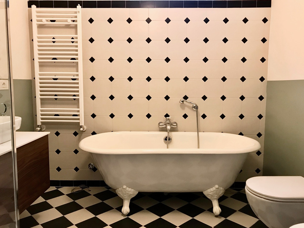 Bild på ett mellanstort 50 tals vit vitt badrum med dusch, med luckor med profilerade fronter, skåp i mörkt trä, ett badkar med tassar, en hörndusch, en toalettstol med separat cisternkåpa, svart och vit kakel, keramikplattor, gröna väggar, klinkergolv i keramik, ett fristående handfat, bänkskiva i kvartsit, vitt golv och dusch med gångjärnsdörr