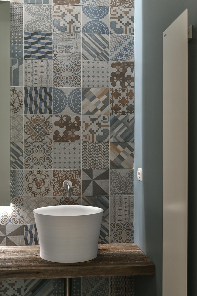 Example of a trendy multicolored tile and porcelain tile medium tone wood floor bathroom design in Venice with open cabinets, dark wood cabinets, blue walls, a vessel sink and wood countertops