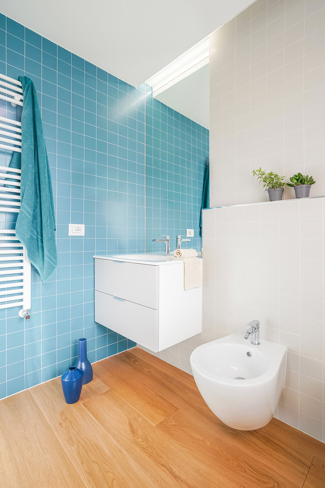 Пример оригинального дизайна: маленькая ванная комната в современном стиле с плоскими фасадами, белыми фасадами, биде, синей плиткой и светлым паркетным полом для на участке и в саду