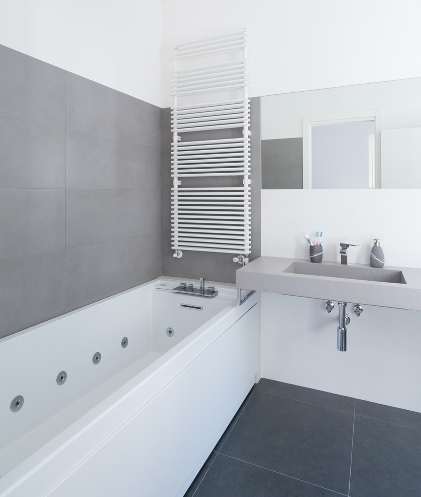Ispirazione per una stanza da bagno contemporanea di medie dimensioni con vasca idromassaggio, piastrelle grigie e pareti bianche