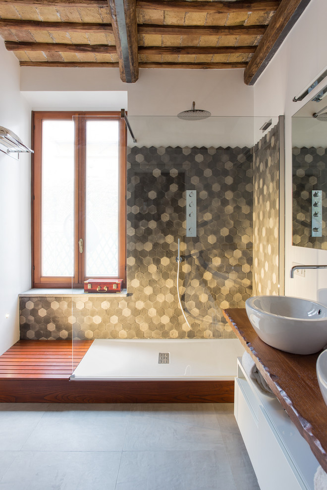 Medelhavsstil inredning av ett mellanstort badrum med dusch, med släta luckor, vita skåp, keramikplattor, vita väggar, ett fristående handfat, träbänkskiva, en hörndusch, grå kakel, grått golv och med dusch som är öppen