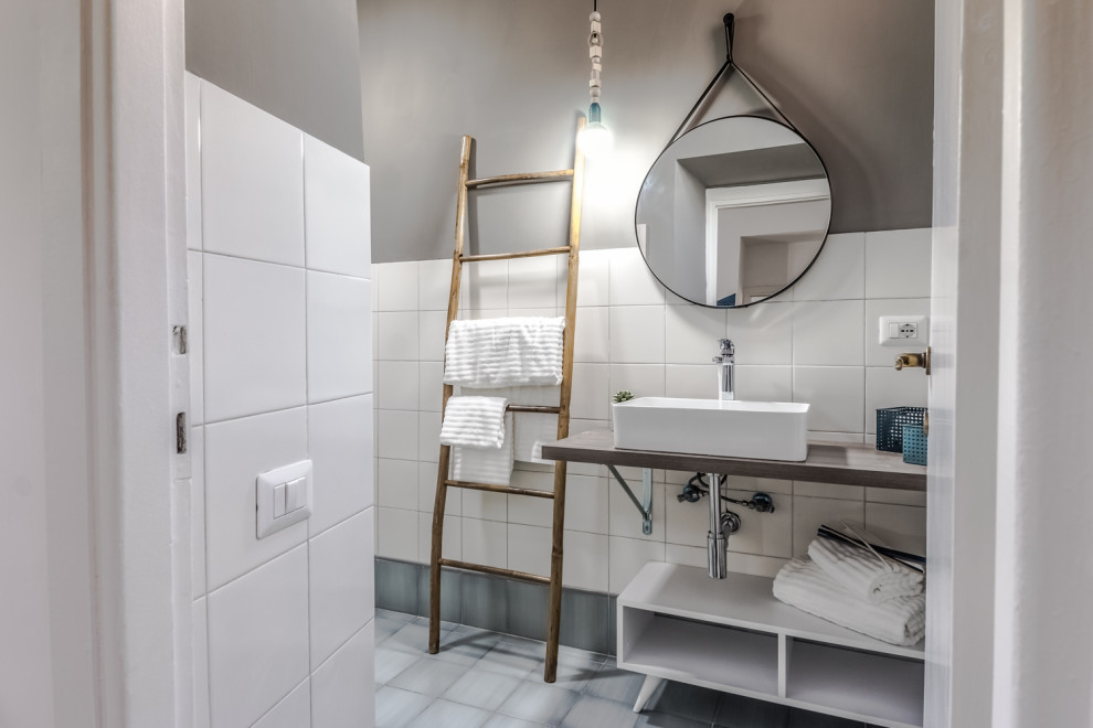 Стильный дизайн: ванная комната в современном стиле с белой плиткой, серыми стенами, настольной раковиной, серым полом, серой столешницей и тумбой под одну раковину - последний тренд