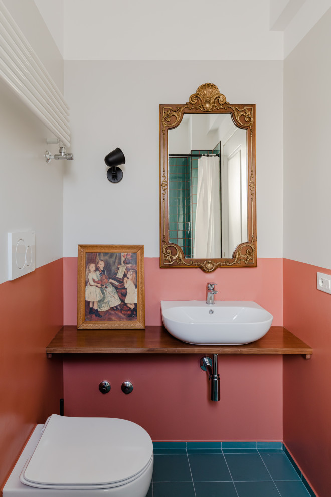 Exemple d'une salle d'eau méditerranéenne de taille moyenne avec WC suspendus, un mur multicolore, un sol en carrelage de porcelaine, une vasque, un plan de toilette en bois, un sol bleu, un plan de toilette marron et meuble-lavabo suspendu.