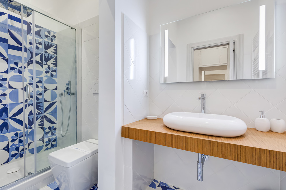 Свежая идея для дизайна: ванная комната среднего размера в современном стиле с душем в нише, биде, синей плиткой, белой плиткой, керамической плиткой, белыми стенами, полом из керамической плитки, душевой кабиной, настольной раковиной, столешницей из ламината, синим полом и душем с раздвижными дверями - отличное фото интерьера