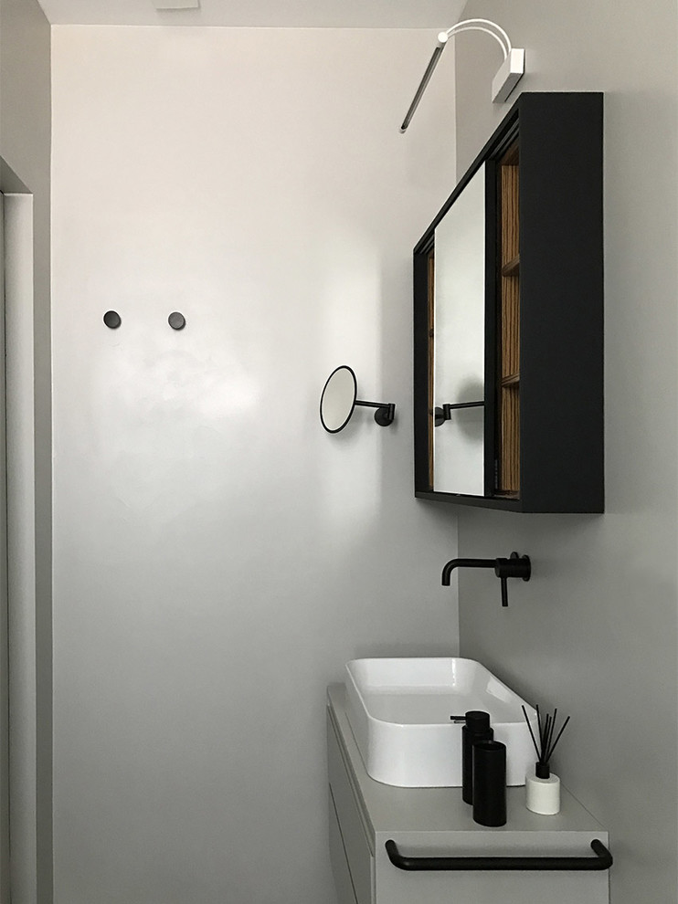 Diseño de cuarto de baño contemporáneo con armarios con paneles lisos, puertas de armario grises, ducha abierta, suelo de cemento, encimera de cemento y encimeras grises