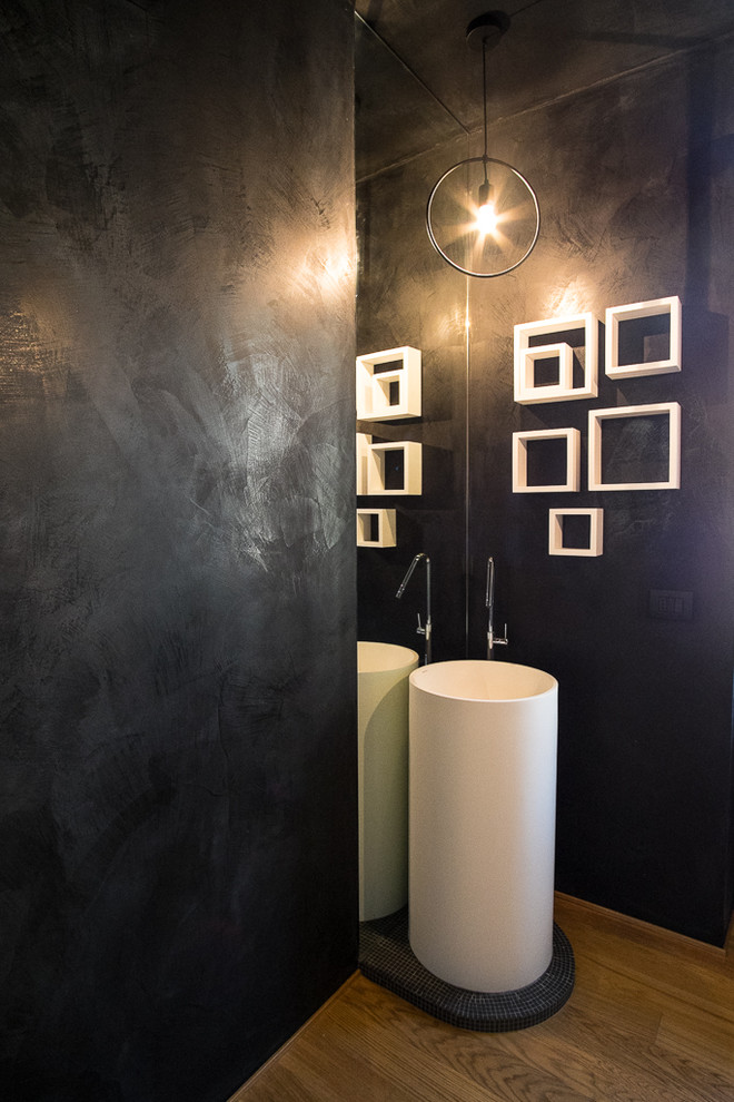 Ispirazione per un piccolo bagno di servizio minimal con WC a due pezzi, pareti nere, pavimento in legno verniciato, lavabo a colonna e pavimento marrone