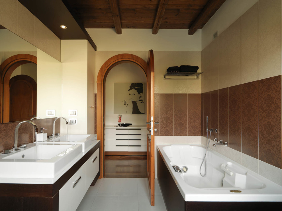 Photo of a contemporary ensuite bathroom in Milan with a vessel sink, flat-panel cabinets, white cabinets, an alcove bath and beige tiles.