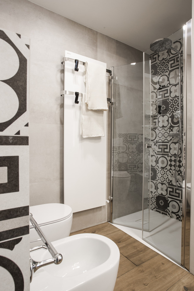 Ispirazione per una stanza da bagno con doccia design di medie dimensioni con doccia a filo pavimento, WC monopezzo, piastrelle di cemento, pavimento in legno massello medio e porta doccia a battente