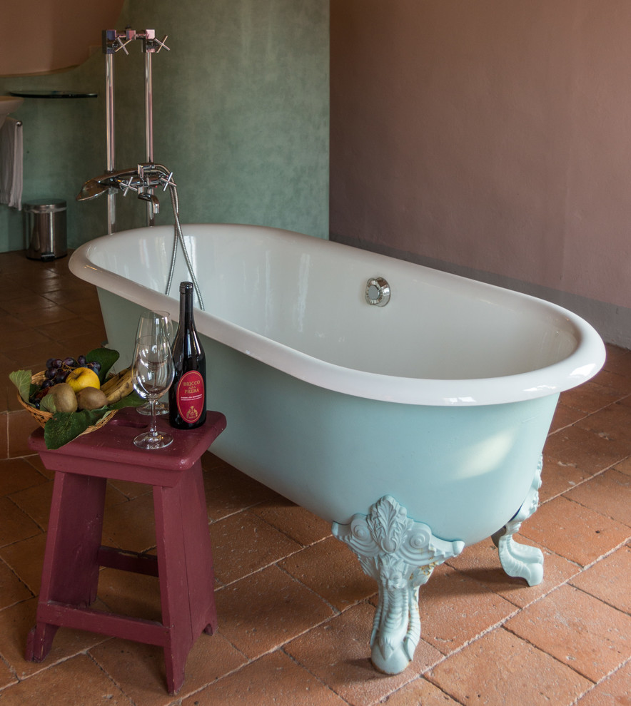 Ejemplo de cuarto de baño de estilo de casa de campo de tamaño medio con bañera con patas, paredes rosas y suelo de ladrillo