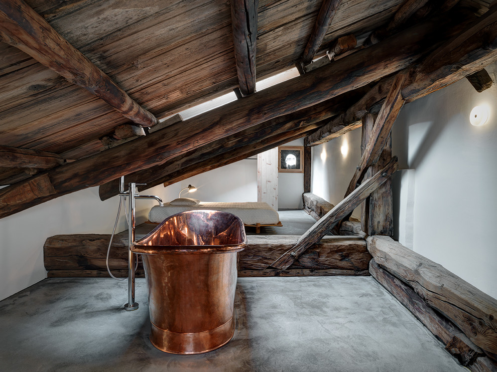Esempio di una grande stanza da bagno padronale rustica con vasca freestanding, pareti bianche, pavimento in cemento e pavimento grigio