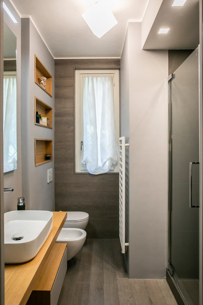 Источник вдохновения для домашнего уюта: ванная комната среднего размера в стиле модернизм с открытыми фасадами, серыми фасадами, открытым душем, раздельным унитазом, серой плиткой, серыми стенами, светлым паркетным полом, душевой кабиной, настольной раковиной, столешницей из дерева, серым полом, душем с распашными дверями и бежевой столешницей