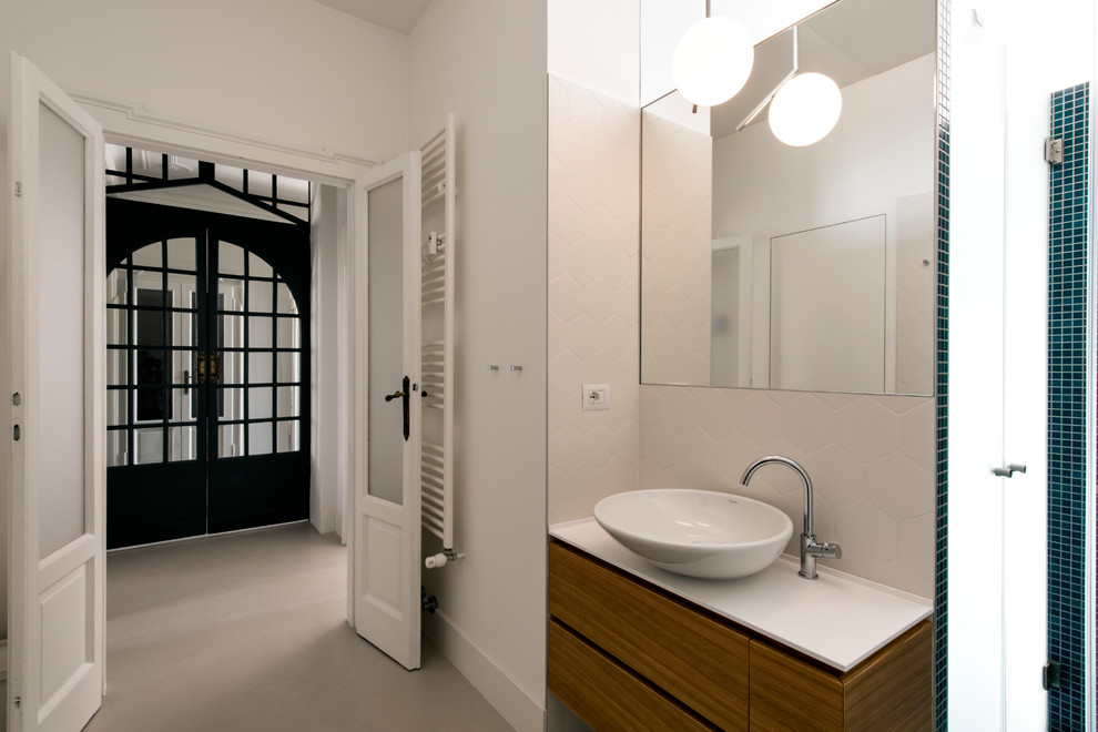 Идея дизайна: ванная комната среднего размера в классическом стиле с плоскими фасадами, светлыми деревянными фасадами, душем без бортиков, инсталляцией, зеленой плиткой, керамогранитной плиткой, белыми стенами, бетонным полом, душевой кабиной, настольной раковиной, столешницей из искусственного кварца, бежевым полом и душем с распашными дверями