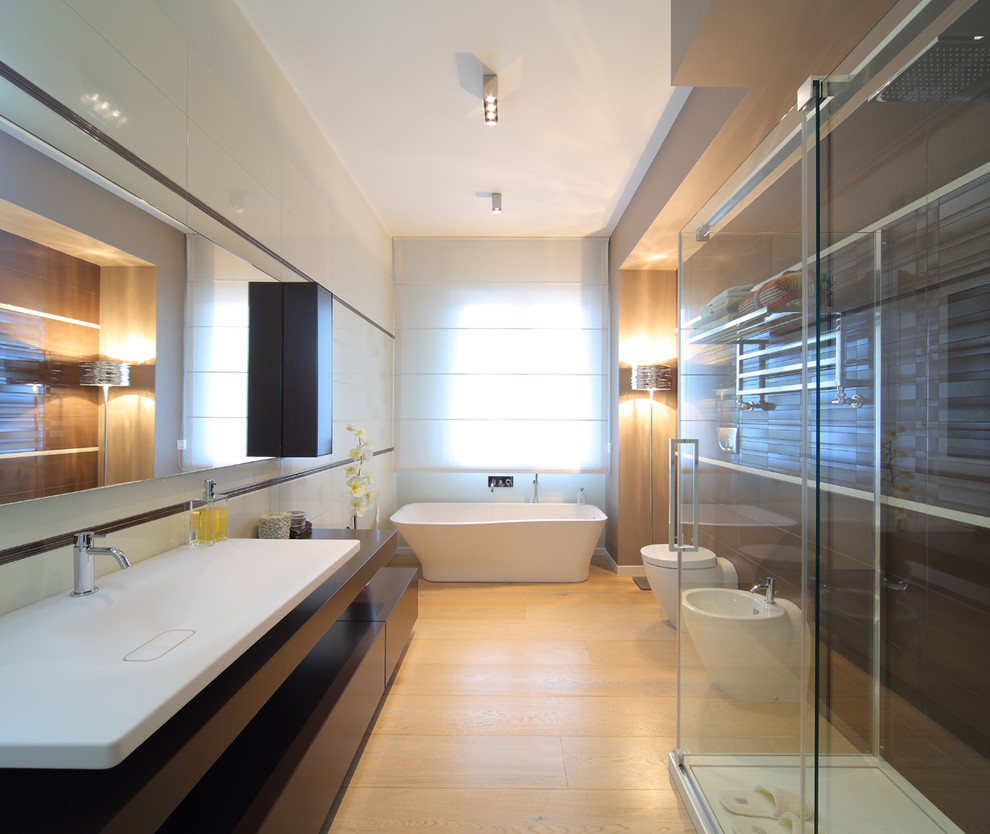 Exemple d'une grande salle de bain principale tendance avec un placard à porte plane, des portes de placard marrons, une baignoire indépendante, une douche d'angle, un bidet, un mur beige, un sol en carrelage de porcelaine, une grande vasque, une cabine de douche à porte coulissante, un carrelage noir et un sol beige.