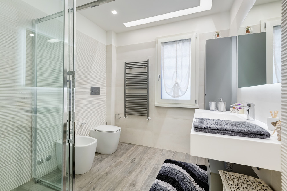 Diseño de cuarto de baño minimalista de tamaño medio con ducha a ras de suelo, sanitario de dos piezas, paredes blancas, suelo de baldosas de porcelana, aseo y ducha, lavabo tipo consola y espejo con luz