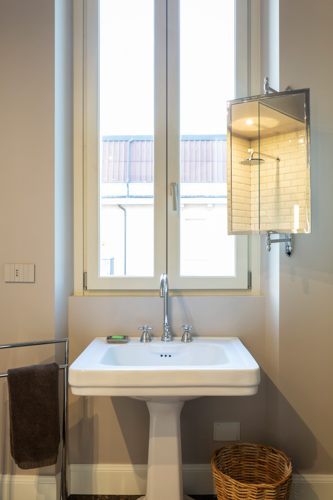 Exempel på ett mellanstort eklektiskt toalett, med vita skåp, en toalettstol med separat cisternkåpa, vit kakel, tunnelbanekakel, grå väggar, marmorgolv, ett piedestal handfat och brunt golv