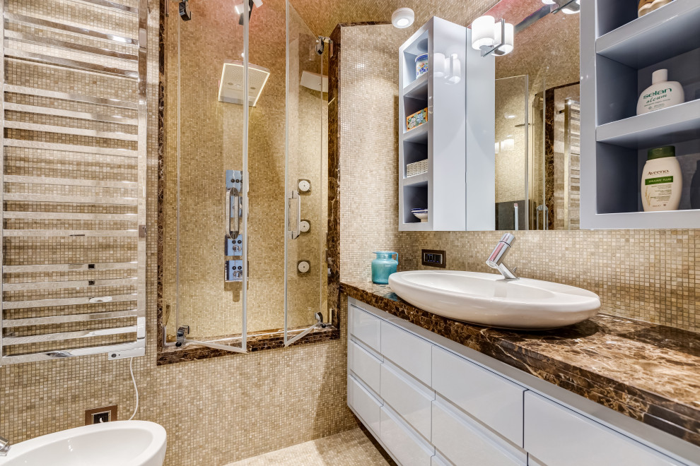 Idée de décoration pour une salle de bain principale design de taille moyenne avec un sol en marbre, un placard avec porte à panneau encastré, des portes de placard turquoises, une baignoire posée, un combiné douche/baignoire, WC suspendus, un carrelage beige, du carrelage en marbre, un mur beige, une vasque, un plan de toilette en marbre, un sol beige, une cabine de douche à porte battante, un plan de toilette marron, un banc de douche, meuble simple vasque, meuble-lavabo encastré, un plafond voûté et un mur en parement de brique.
