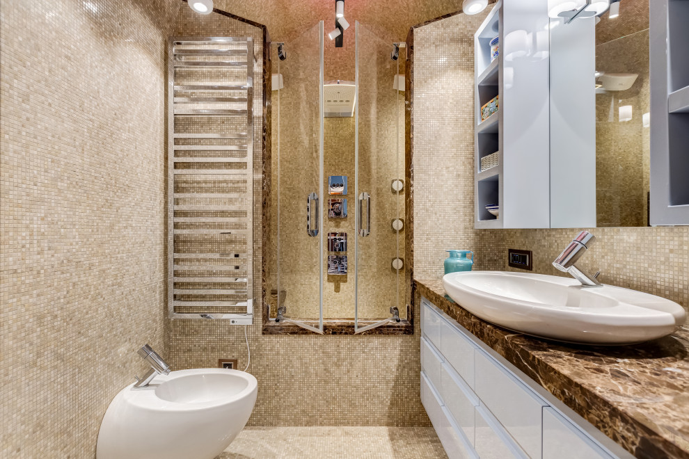На фото: главная ванная комната среднего размера в стиле модернизм с мраморным полом, фасадами с утопленной филенкой, бирюзовыми фасадами, накладной ванной, душем над ванной, бежевой плиткой, мраморной плиткой, бежевыми стенами, мраморной столешницей, бежевым полом, душем с распашными дверями, коричневой столешницей, сиденьем для душа, тумбой под одну раковину, встроенной тумбой, сводчатым потолком и кирпичными стенами с