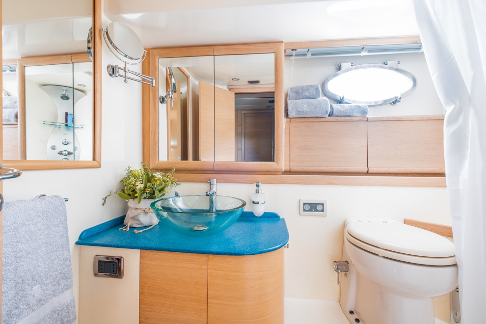 На фото: маленькая ванная комната в современном стиле с плоскими фасадами, светлыми деревянными фасадами, угловым душем, унитазом-моноблоком, белой плиткой, белыми стенами, темным паркетным полом, душевой кабиной, настольной раковиной, столешницей из искусственного кварца, коричневым полом, шторкой для ванной, синей столешницей, тумбой под одну раковину и встроенной тумбой для на участке и в саду