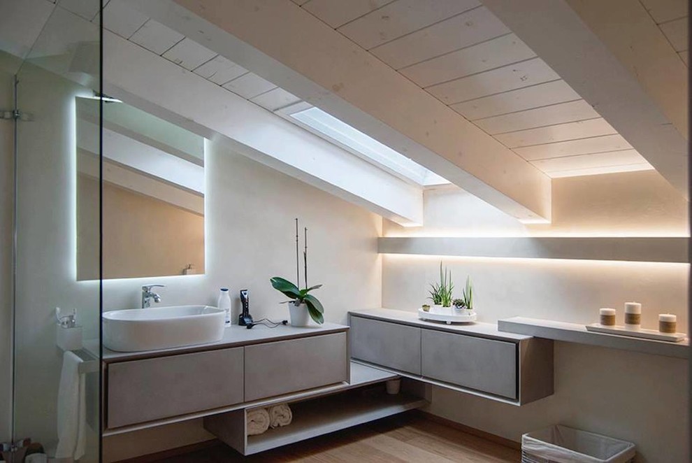 Réalisation d'une salle de bain design avec un placard à porte plane, des portes de placard beiges, un mur beige, parquet clair, une vasque et un sol beige.
