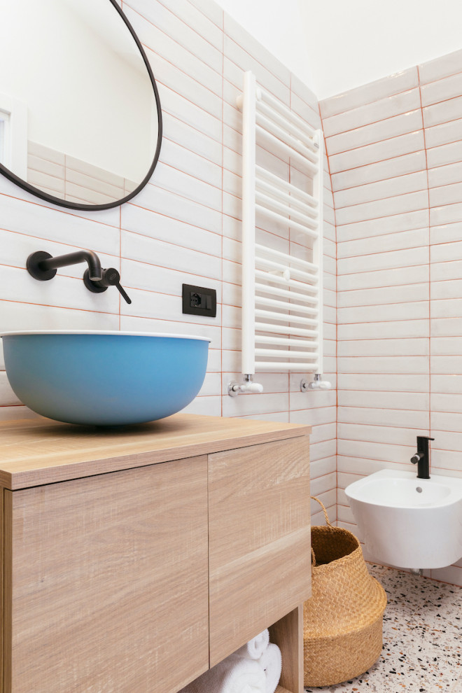 Foto på ett litet funkis badrum med dusch, med skåp i ljust trä, en kantlös dusch, en vägghängd toalettstol, ett fristående handfat, träbänkskiva och dusch med skjutdörr