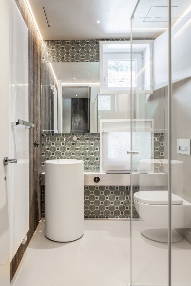 Idee per una piccola stanza da bagno con doccia design con WC sospeso, pareti multicolore, lavabo a colonna, pavimento bianco, doccia ad angolo e porta doccia a battente