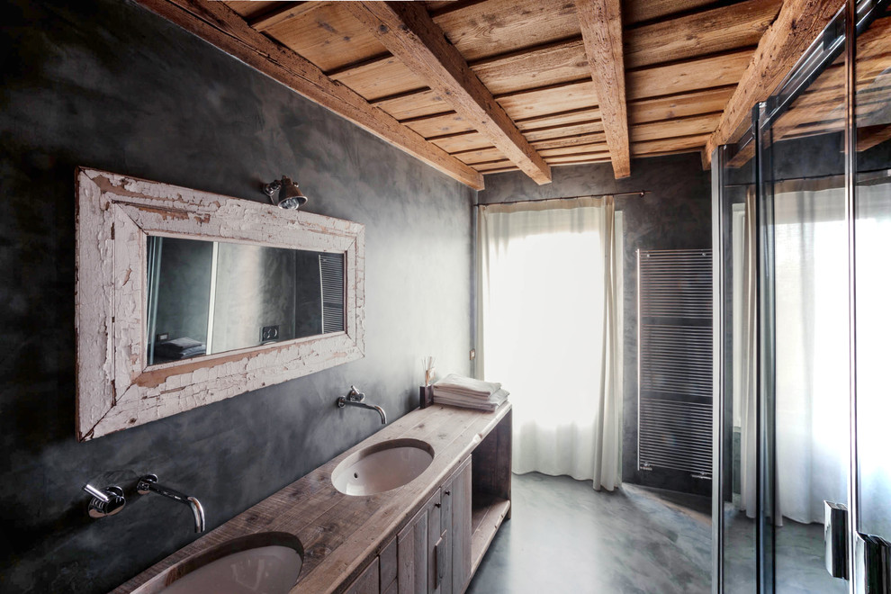 Idee per una stanza da bagno con doccia country con ante in legno chiaro, pareti grigie, lavabo da incasso, top in legno, doccia a filo pavimento e pavimento grigio