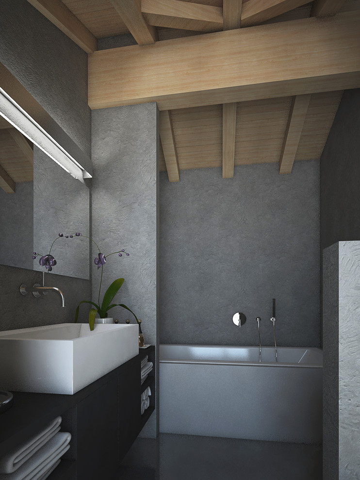 Immagine di una stanza da bagno padronale minimalista di medie dimensioni con vasca ad alcova, pareti grigie, pavimento in cemento, lavabo a bacinella e pavimento grigio