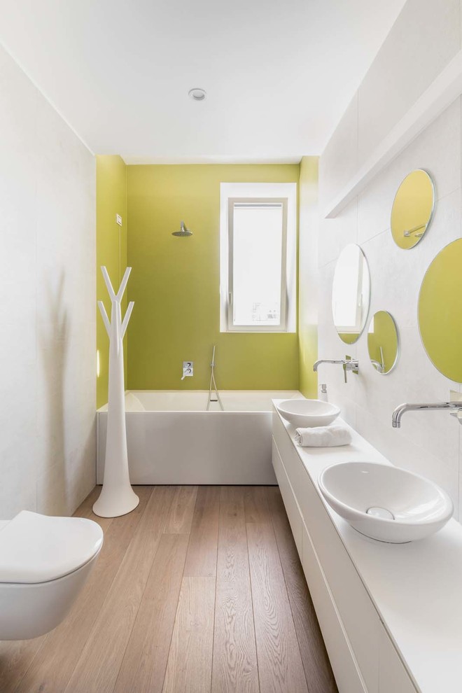 Идея дизайна: ванная комната в современном стиле с плоскими фасадами, белыми фасадами, ванной в нише, душем над ванной, зеленой плиткой, белыми стенами, светлым паркетным полом, настольной раковиной и душевой кабиной