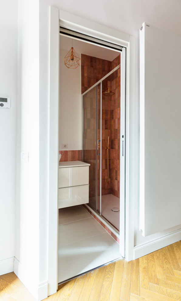 Пример оригинального дизайна: маленькая ванная комната в современном стиле с плоскими фасадами, белыми фасадами, душем в нише, инсталляцией, розовой плиткой, керамической плиткой, белыми стенами, полом из керамогранита, душевой кабиной, настольной раковиной, бежевым полом, душем с раздвижными дверями, белой столешницей, тумбой под одну раковину и подвесной тумбой для на участке и в саду