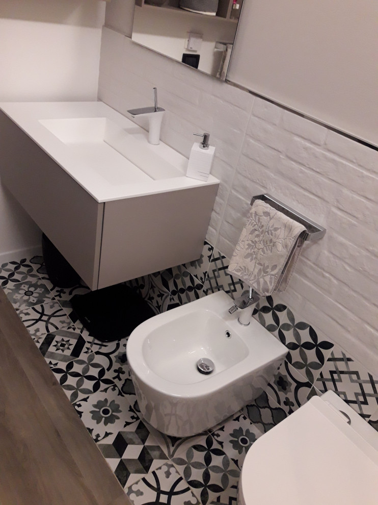На фото: маленькая ванная комната в современном стиле с плоскими фасадами, серыми фасадами, душем без бортиков, инсталляцией, черно-белой плиткой, керамической плиткой, серыми стенами, полом из керамической плитки, душевой кабиной, монолитной раковиной, душем с раздвижными дверями, белой столешницей, тумбой под одну раковину, подвесной тумбой и многоуровневым потолком для на участке и в саду с