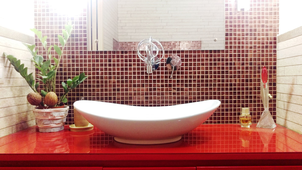 Cette photo montre une salle de bain principale éclectique de taille moyenne avec un placard à porte plane, des portes de placard rouges, une baignoire d'angle, WC suspendus, un carrelage beige, des carreaux en allumettes, un mur blanc, un sol en carrelage de porcelaine, une vasque, un plan de toilette en surface solide, un sol beige et un plan de toilette rouge.