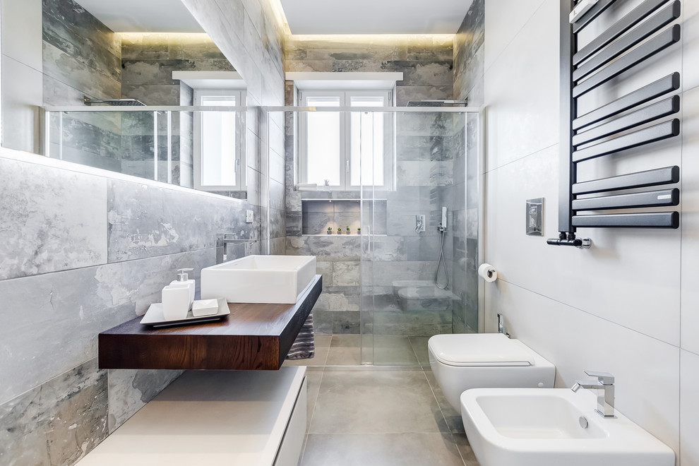 Modernes Duschbad mit offenen Schränken, Duschnische, Wandtoilette, Aufsatzwaschbecken, Waschtisch aus Holz, grauem Boden, Schiebetür-Duschabtrennung und brauner Waschtischplatte in Rom